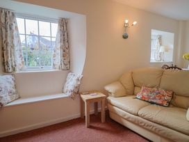 A living room with a sofa and window at Vine Cottage in Burton Bradstock