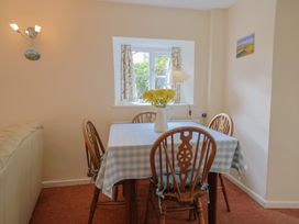 A dining room with a table and chairs at Vine Cottage in Burton Bradstock