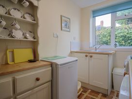 A kitchen with cabinets and a sink at Vine Cottage in Burton Bradstock