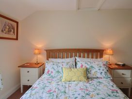 A bedroom with a bed and bedside lamps at Vine Cottage in Burton Bradstock