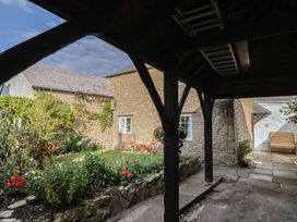 A garden with chairs and a table at Vine Cottage in Burton Bradstock