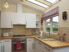 A kitchen with white cabinets and wooden countertops at St Leonards Salcombe