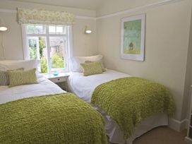 A bedroom with two beds and artwork at St Leonards in Salcombe