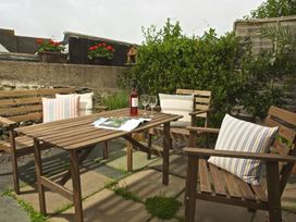 A garden seating area with a table and chairs at St Leonards in Salcombe