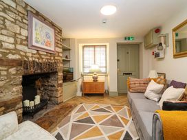 A living room with a fireplace and sofa at 29 Spring Street in Chipping Norton