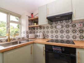 A kitchen with sink, stove, and shelf at 29 Spring Street in Chipping Norton