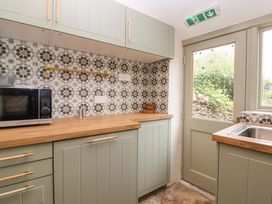 A kitchen with cabinets and a microwave at 29 Spring Street Chipping Norton