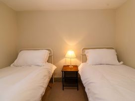 A bedroom with two beds and a lamp on a nightstand at 29 Spring Street Chipping Norton