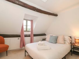 A bedroom with a bed and armchair at 6 Priory Lane Burford