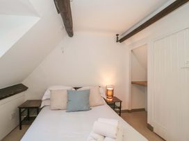 A bedroom with a bed and bedside table at 6 Priory Lane in Burford