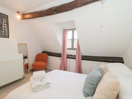 A bedroom with a bed and chair at 6 Priory Lane Burford