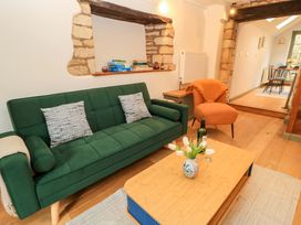 A living room with a green sofa and a wooden coffee table at 6 Priory Lane Burford