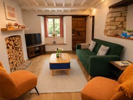 A living room with a sofa and television at Burford Apple in Burford