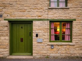 An exterior view of a house with a green door and window at Burford Apple in Burford