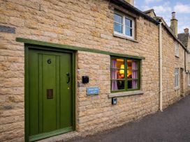 A green door and window on a stone building at Burford Apple in Burford