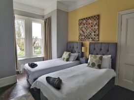 A bedroom with two beds and a lamp at Roselyn House in Par