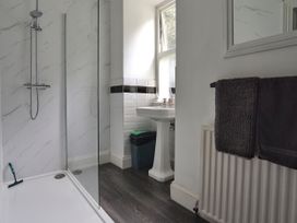 A bathroom with a shower, sink and towel at Roselyn House in Par
