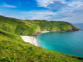 A beach with hills and ocean at Roselyn House in Par