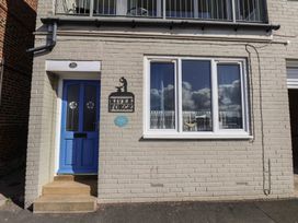An exterior view with a blue door, window, and sign at Farriers Yard in Whitby