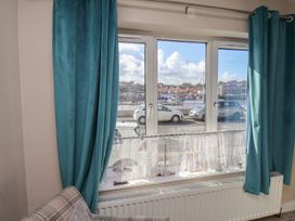 A living room with a view of the marina and parked cars at Farriers Yard in Whitby