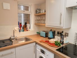 A kitchen with a sink, shelves, and appliances at Farriers Yard in Whitby