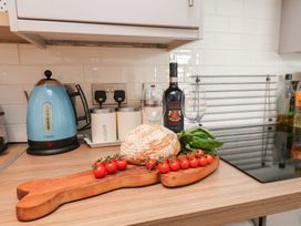 A kitchen with a kettle, wine bottles, and cherry tomatoes at Farriers Yard, Whitby