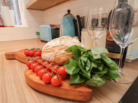 A kitchen with bread, tomatoes, basil, and wine at Farriers Yard, Whitby