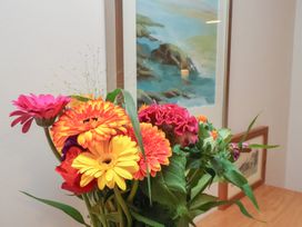 A display of flowers in a vase with a painting in the background at Farriers Yard, Whitby