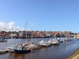 A harbor with boats and buildings at Farriers Yard in Whitby
