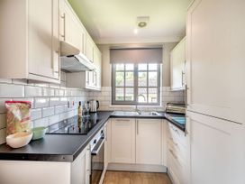 A kitchen with white cabinets and a countertop at Bargany in Girvan
