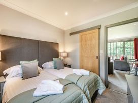 A bedroom with twin beds and an adjoining living area at Bargany in Girvan