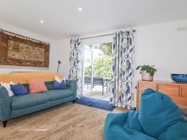 A living room with a couch and door leading to a patio at Hillbre Trevone