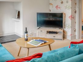 A living room with a television and coffee table at Summerleaze Cottage 2 Spa in Bude