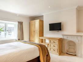 A bedroom with a bed and wooden furniture at Summerleaze Cottage 2 Spa in Bude