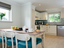 A kitchen with dining table and chairs at Summerleaze Cottage 2 Spa in Bude