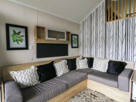 A living room with a sofa and wall art at The Family Pod in Swansea