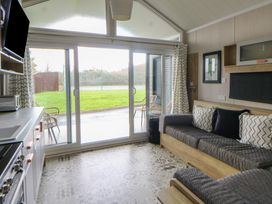 A living room with a sofa and television at The Family Pod in Swansea