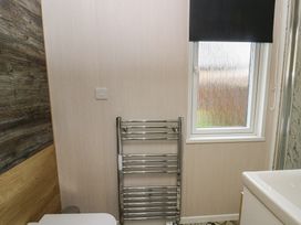 A bathroom with a window and towel rail at The Family Pod in Swansea