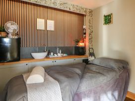A treatment room with a massage bed and sink at The Family Pod in Swansea