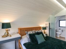 A bedroom with a bed and an attached bathroom at Garden Lodge 1 in Swansea