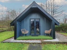 A cabin with chairs and a pathway at Garden Lodge 2 Swansea