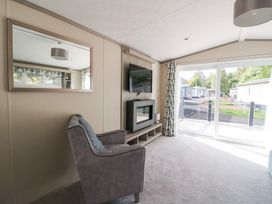A living room with a chair and television at Altair Lodge