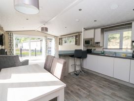 A kitchen with dining table and open layout at Altair Lodge