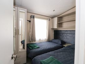 A bedroom with two beds and a wardrobe at Altair Lodge