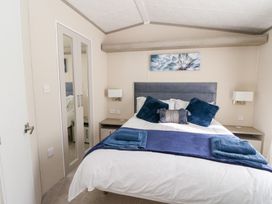 A bedroom with a bed and mirror at Altair Lodge 