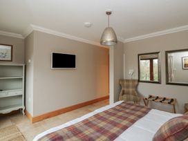 A bedroom with a bed and television at Oak Tree Cottage in Swansea