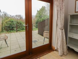 A living room with a sliding door leading to a patio at Oak Tree Cottage Swansea