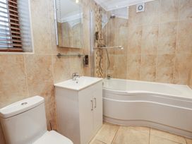 A bathroom with a toilet, sink, and shower at Oak Tree Cottage in Swansea