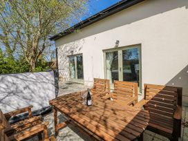 An outdoor area with a wooden table and chairs at Oak Tree Cottage in Oldwalls, Llanrhidian, Gower