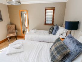A bedroom with twin beds and a chair at Oak Tree Cottage, Oldwalls, Llanrhidian, Gower